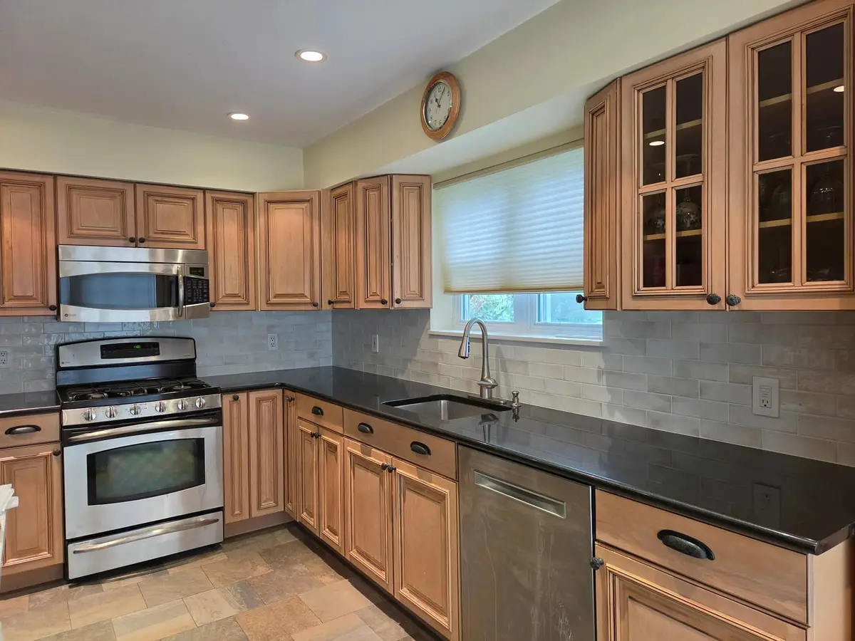 Subway Tile Kitchen Refresh — Light gray subway tile in a clean brick pattern, replacing an outdated tumbled-stone backsplash